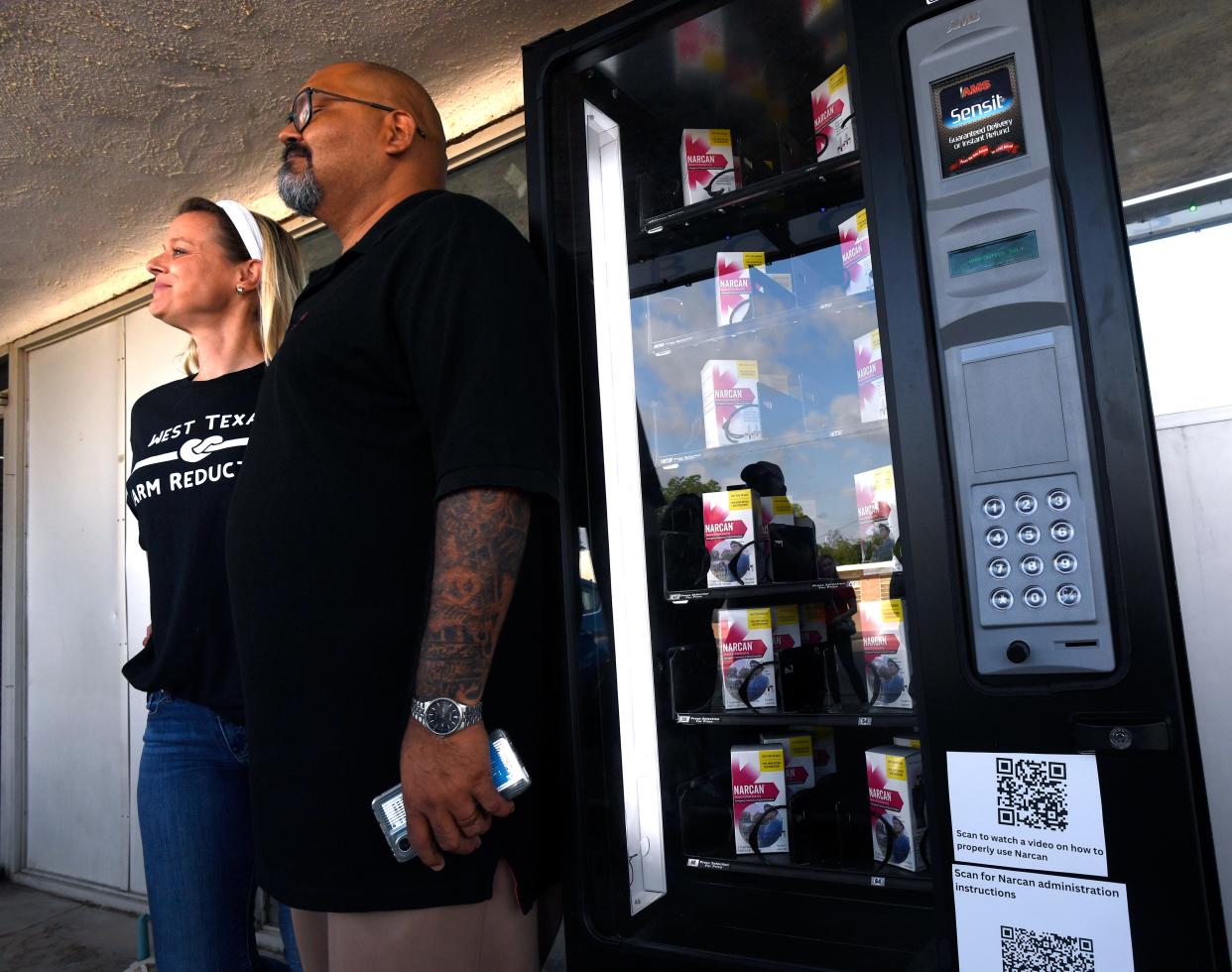 Devon Edwards (left) and Michael Prado stand beside the Narcan vending machine for a photo after its dedication ceremony July 31. The machine offers free boxes of the anti-opiate treatment and is located outside Book Therapy in Abilene.