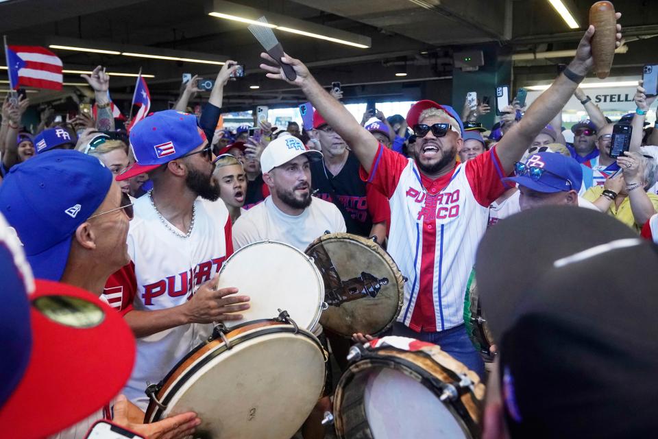 A group of Puerto Rican musicians play for fans before the start of a World Baseball Classic game between Puerto Rico and Nicaragua, Saturday, March 11, 2023, in Miami. (AP Photo/Marta Lavandier)