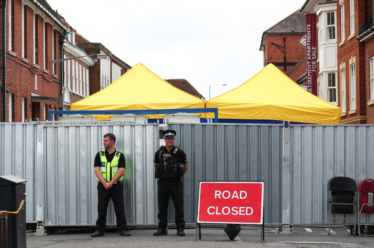 Police officers stand outside the street where Dawn Sturgess lived before dying after being exposed to a Novichok nerve agent, in Salisbury