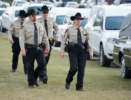 Law enforcement officers arrive for a funeral for six members of the Holcombe family and three members of the Hill family, victims of the Sutherland Springs Baptist church shooting, in Floresville, Texas, U.S. November 15, 2017. REUTERS/Darren Abate