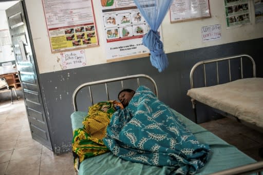 A woman lies in a Mozambican hospital with her newborn baby. Lack of equipment, funding, staff and drugs are common problems in African health systems