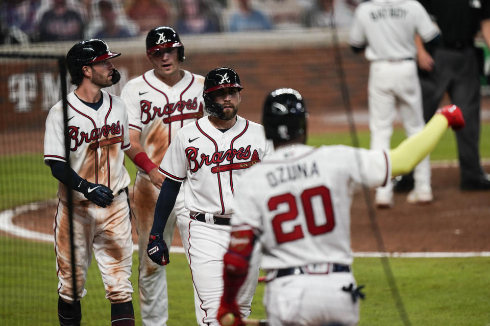 Atlanta Braves' Dansby Swanson, left, Ender Inciarte, center, and Austin Riley return to the dugout after scoring in a double by Ronald Acuna Jr. during the sixth inning of a baseball game against the Miami Marlins on on Wednesday, Sept. 9, 2020, in Atlanta. (AP Photo/Brynn Anderson)