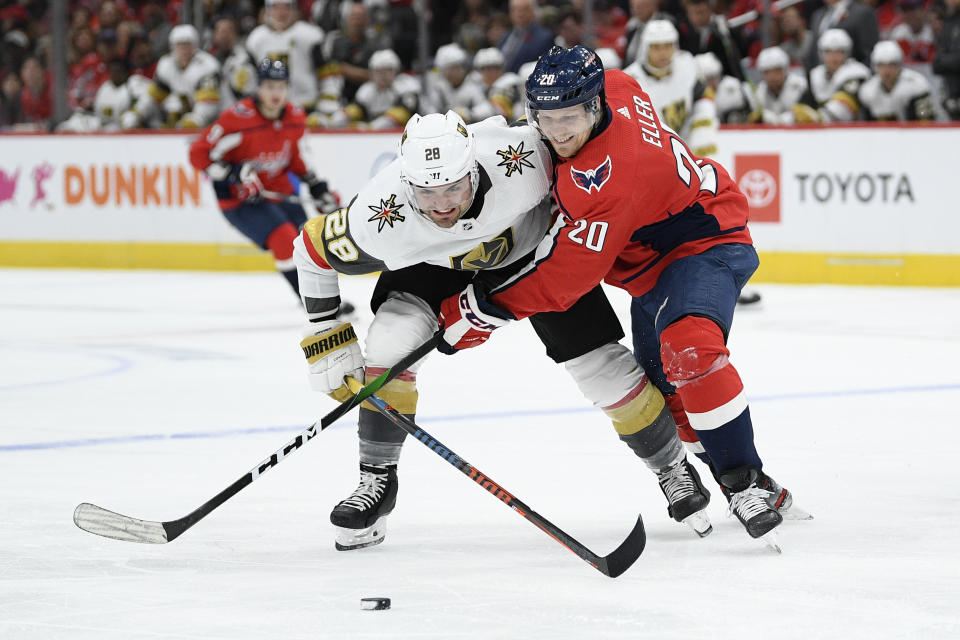 Washington Capitals center Lars Eller (20), of Denmark, and Vegas Golden Knights left wing William Carrier (28) fight fro the puck during the second period of an NHL hockey game, Saturday, Nov. 9, 2019, in Washington. (AP Photo/Nick Wass)