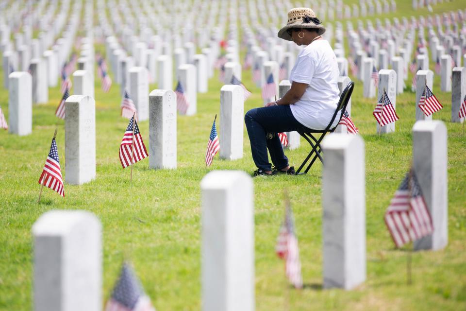 Yvetta Goodman sits and looks down at her grandfather’s grave after the 2023 Memorial Day Ceremony at the West Tennessee State Veterans Cemetery in Memphis, Tenn., on Monday, May 29, 2023. Goodman’s grandmother is buried on the other side and she said she and her husband Melvin, who is a Navy veteran, come to visit them “all the time.” “Memorial Day especially because I recognize all the military men not just grandaddy but all the people who sacrificed,” she said. “It means a whole lot to us both.”