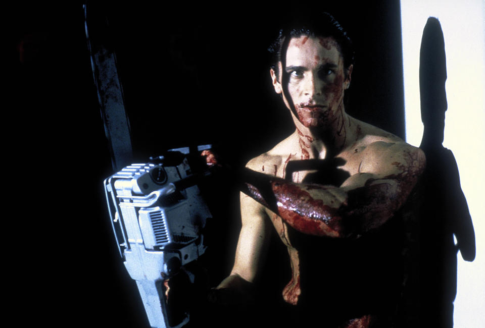 A bloodied man holds a chainsaw