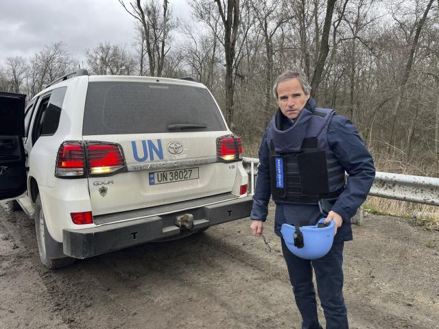 In this photo provided by the IAEA Press Office, U.N. atomic energy chief Rafael Mariano Grossi stands on a road next to a UN vehicle on his way to the Zaporizhzhia Nuclear Power Plant, in southeastern Ukraine, Wednesday March 29, 2023. (IAEA Press Office via AP)