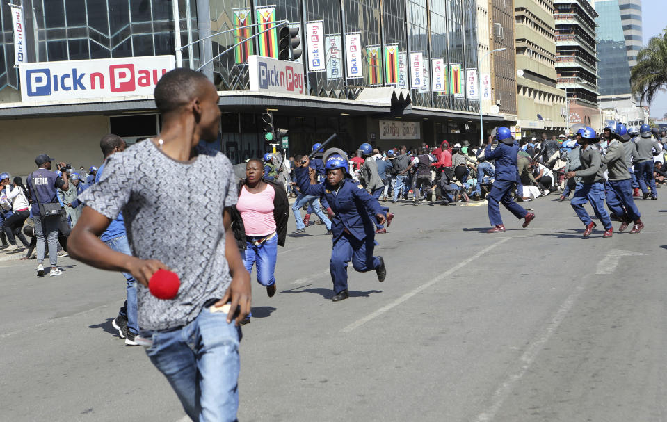 Riot police arrest and forcibly apprehend protestors during protests in Harare, Friday, Aug. 16, 2019. The main opposition Movement For Democratic Change party is holding protests over deteriorating economic conditions in the country as well as to try and force Zimbabwean President Emmerson Mnangagwa to set up a transitional authority to address the crisis and organize credible elections. (AP Photo/Tsvangirayi Mukwazhi)