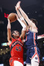 Toronto Raptors guard Dalano Banton (45) goes to the basket against Washington Wizards forward Deni Avdija (9) during first-half NBA basketball game action in Toronto, Sunday, Dec. 5, 2021. (Cole Burston/The Canadian Press via AP)