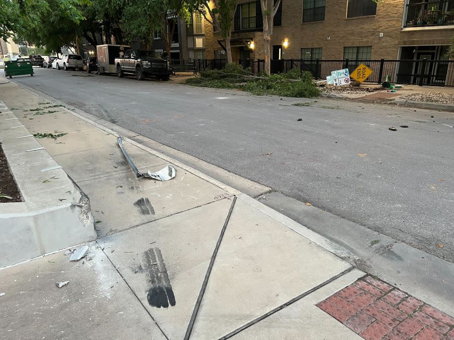 Damage to cars, street signs, etc. along East 9th Street near Embassy Drive after an 18-wheeler crashed into 10 parked vehicles overnight April 22, 2024 (KXAN Photo/Todd Bailey)