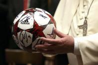 Pope Francis holds an autographed football he received from Bayern Munich's soccer team during a private audience at the Palace of the Vatican in Vatican City, October 22, 2014. REUTERS/Alexander Hassenstein