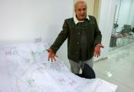 Nazih Brek, urbaniste au Centre al-Marsad pour les droits de l'homme, montre une carte du Golan syrien annexé par Israël, à Majdal Shams, dans cette zone, le 28 décembre 2021 (AFP/Ahmad GHARABLI)