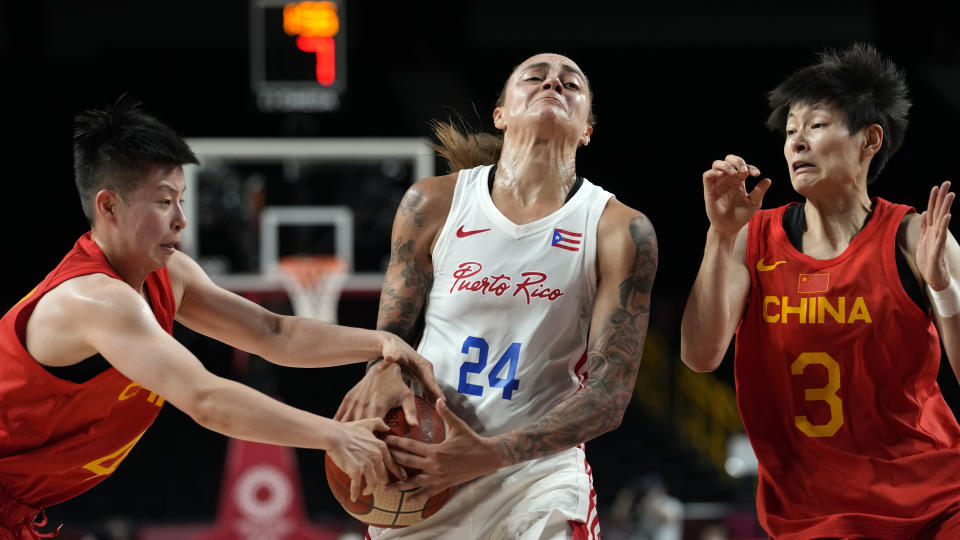 Puerto Rico's Jazmon Gwathmey (24) drives between China's Yuan Li (4) and Liwei Yang (3) during a women's basketball preliminary round game at the 2020 Summer Olympics in Saitama, Japan, Tuesday, July 27, 2021. (AP Photo/Eric Gay)