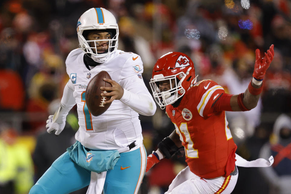 KANSAS CITY, MISSOURI - JANUARY 13: Tua Tagovailoa #1 of the Miami Dolphins runs as he is pursued by Mike Edwards #21 of the Kansas City Chiefs during the second half in the AFC Wild Card Playoffs at GEHA Field at Arrowhead Stadium on January 13, 2024 in Kansas City, Missouri. (Photo by David Eulitt/Getty Images)