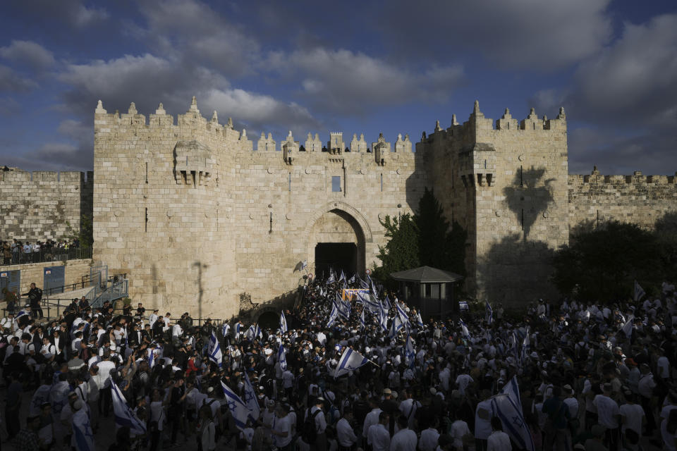 Israelis dance and wave national flags during a march marking Jerusalem Day, an Israeli holiday celebrating the capture of east Jerusalem in the 1967 Mideast war, in front of the Damascus Gate of Jerusalem's Old City, Thursday, May 18, 2023. (AP Photo/Mahmoud Illean)