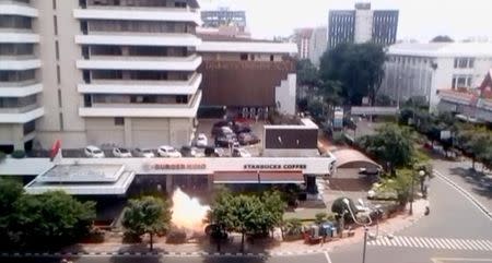 A bomb explosion is seen outside a Starbucks shop in Jakarta, Indonesia in this still image taken from amateur video shot on January 14, 2016. REUTERS/Amateur video via Reuters TV