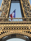 A French firefighter adjusts the French flag on the Eiffel Tower, in Paris, Sunday, Aug. 25, 2019. Firefighters unfurled a huge French flag from the Eiffel Tower, recreating the moment when a French tricolor stitched together from sheets was hoisted atop the monument 75 years ago to replace the swastika flag that had flown for four years. (AP Photo/Michel Spingler)