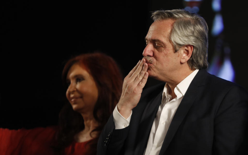 Peronist presidential candidate Alberto Fernández blows a kiss to supporters after incumbent President Mauricio Macri conceded defeat at the end of election day in Buenos Aires, Argentina, Sunday, Oct. 27, 2019. Behind is running mate, former President Cristina Fernández. (AP Photo/Natacha Pisarenko)