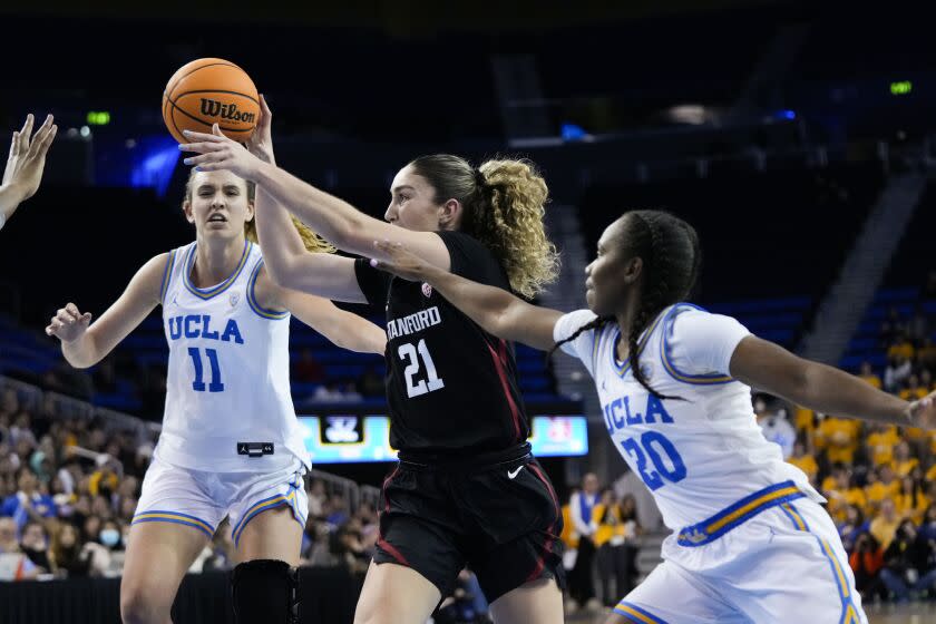 Stanford forward Brooke Demetre (21) passes the ball as UCLA guard Charisma Osborne (20) and forward Emily Bessoir.