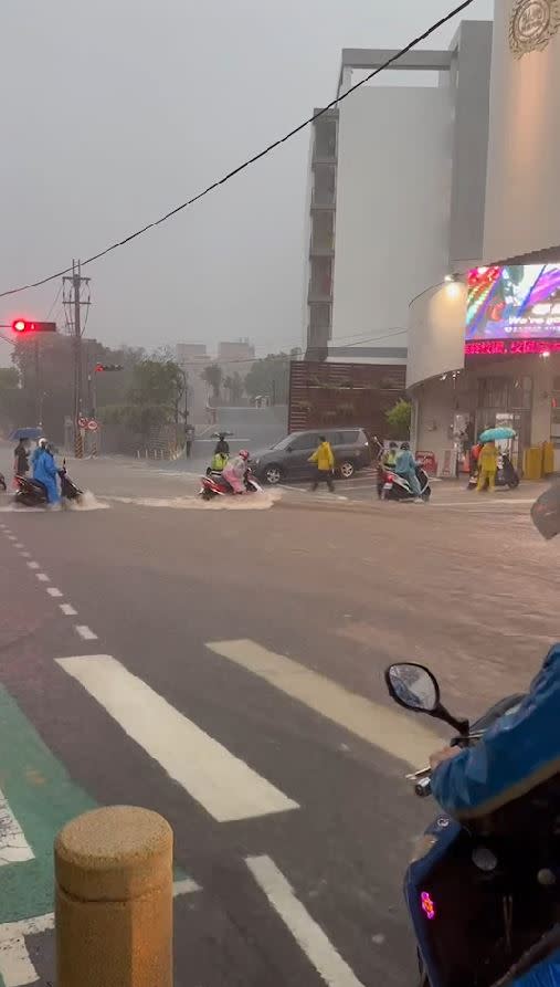 暴雨襲擊台中，弘光科大學生冒險涉水而過，女學生站不穩差點被湍急洪水沖走。(圖／翻攝自記者爆料網)