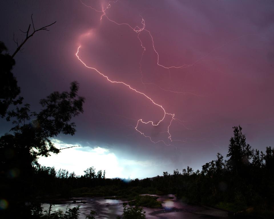 Lightning moves across the sky Tuesday evening over the McKenzie River near Hayden Bridge in Springfield.