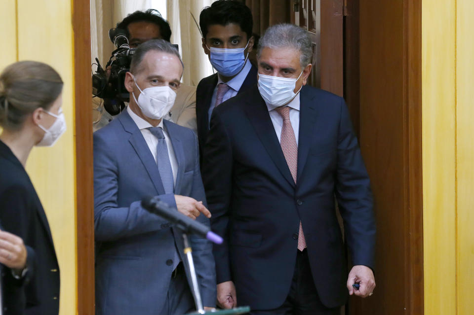 Pakistan's Foreign Minister Shah Mahmood Qureshi, right, and his German counterpart Heiko Maas, center, arrives for a press conference after their meeting in Islamabad, Pakistan, Tuesday, August 31, 2021. Maas arrived in Islamabad on two-day visit to hold talks with Pakistani leadership to discuss bilateral matters, international issues and the current situation in Afghanistan. (AP Photo/Anjum Naveed)