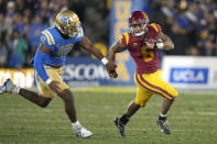 Southern California running back Austin Jones, right, runs the ball as UCLA defensive lineman Grayson Murphy gives chase during the second half of an NCAA college football game Saturday, Nov. 19, 2022, in Pasadena, Calif. (AP Photo/Mark J. Terrill)