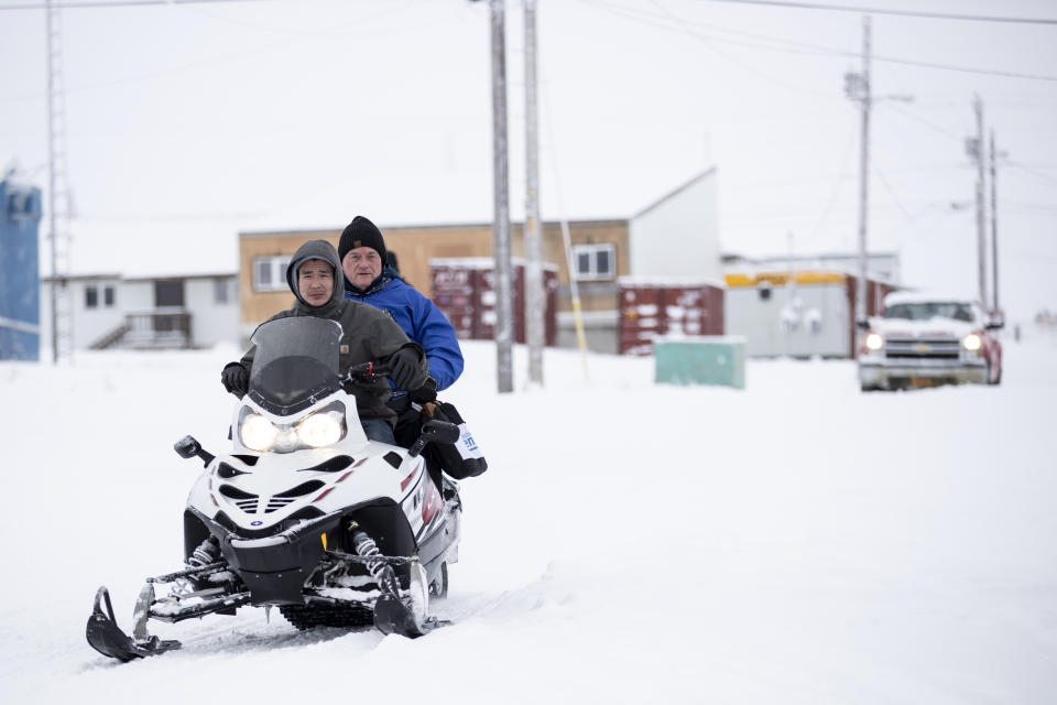Census bureau director Steven Dillingham, center in blue jacket, rides behind Dennis Kashatok, left, as they arrive to conduct the first enumeration of the 2020 Census Tuesday, Jan. 21, 2020, in Toksook Bay, Alaska. (AP Photo/Gregory Bull)