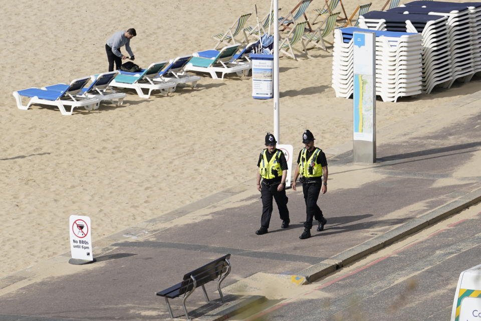 Officers walk beside Bournemouth beach on Thursday after police launched an investigation. (PA)