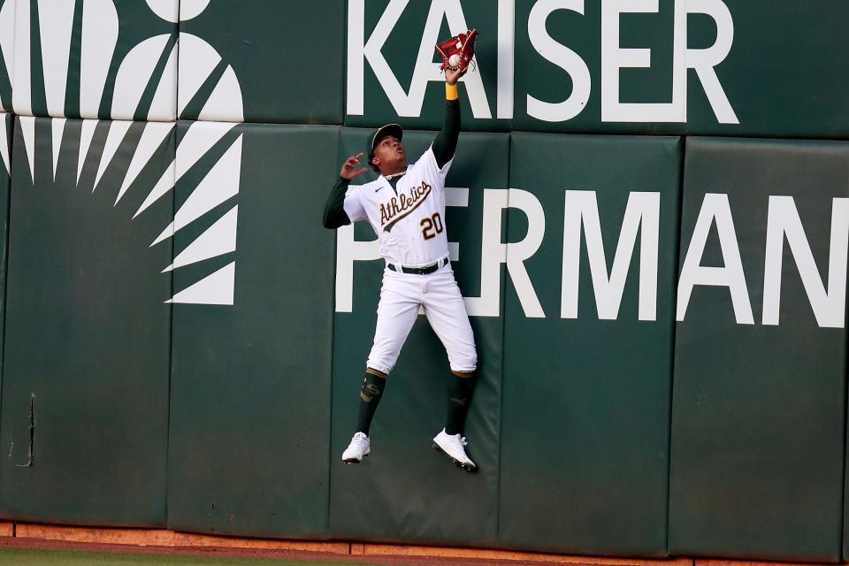 Oakland Athletics' Cristian Pache (20) catches a ball hit by Baltimore Orioles' Kelvin Gutierrez during the second inning of a baseball game in Oakland, Calif., on Tuesday, April 19, 2022. (AP Photo/Scot Tucker)