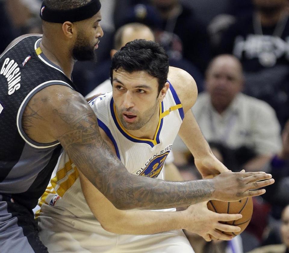 FILE - In this Jan. 8, 2017 file photo, Golden State Warriors center Zaza Pachulia looks past Sacramento Kings forward DeMarcus Cousins during the team's NBA basketball game in Sacramento, Calif. Pachulia is among quite a few Warriors who build team chemistry on flights between games by playing very competitive games of poker. With all that was made before the season about adding Kevin Durant to an already star-studded roster, Golden State's players have jelled just fine. (AP Photo/Rich Pedroncelli, File)