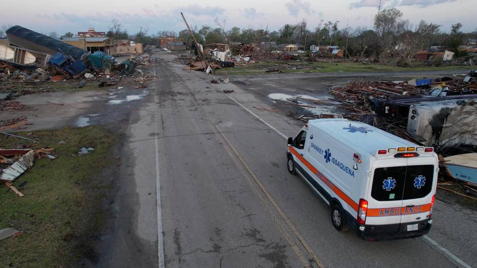 An ambulance drives along a road, near destroyed buildings and vehicles, in the aftermath of a tornado, in Rolling Fork, Mississippi, U.S. March 25, 2023 in this screengrab obtained from a video. SevereStudios.com / Jordan Hall/via REUTERS THIS IMAGE HAS BEEN SUPPLIED BY A THIRD PARTY. MANDATORY CREDIT.