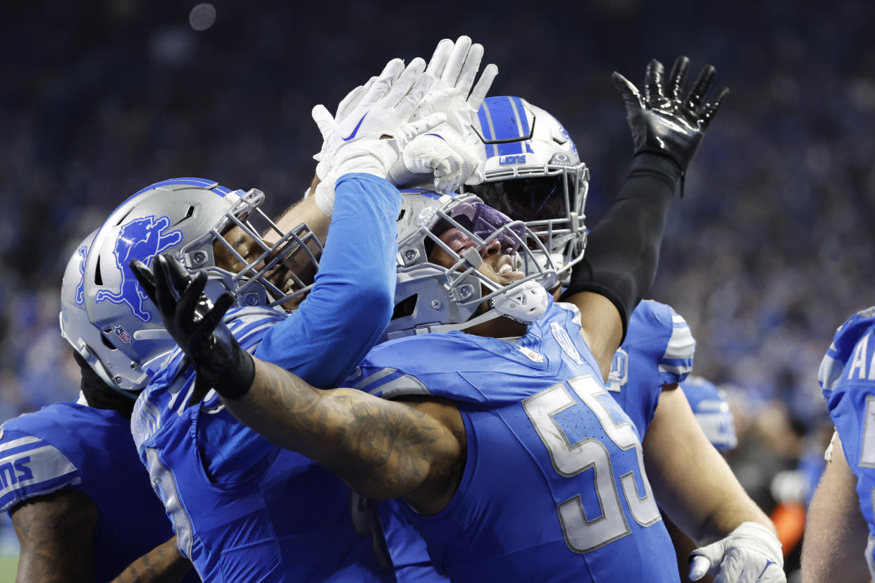 Detroit Lions linebacker Derrick Barnes (55) receives congratulations from teammates after he makes an interception in the fourth quarter against the Tampa Bay Buccaneers during an NFL divisional round playoff football game Sunday, Jan. 21, 2024, in Detroit. (AP Photo/Rick Osentoski)