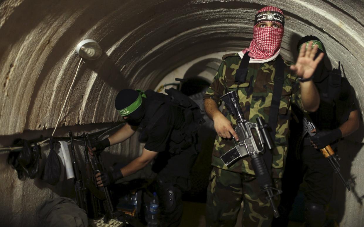 A Palestinian fighter from the Izz el-Deen al-Qassam Brigades, the armed wing of the Hamas movement, gestures inside an underground tunnel in Gaza in this August 18, 2014