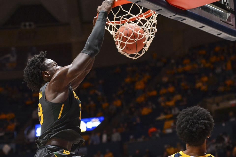 Baylor forward Jonathan Tchamwa Tchatchoua (23) dunks the ball while being guarded by West Virginia guard Taz Sherman (12) during the second half of an NCAA college basketball game in Morgantown, W.Va., Tuesday, Jan. 18, 2022. (William Wotring)