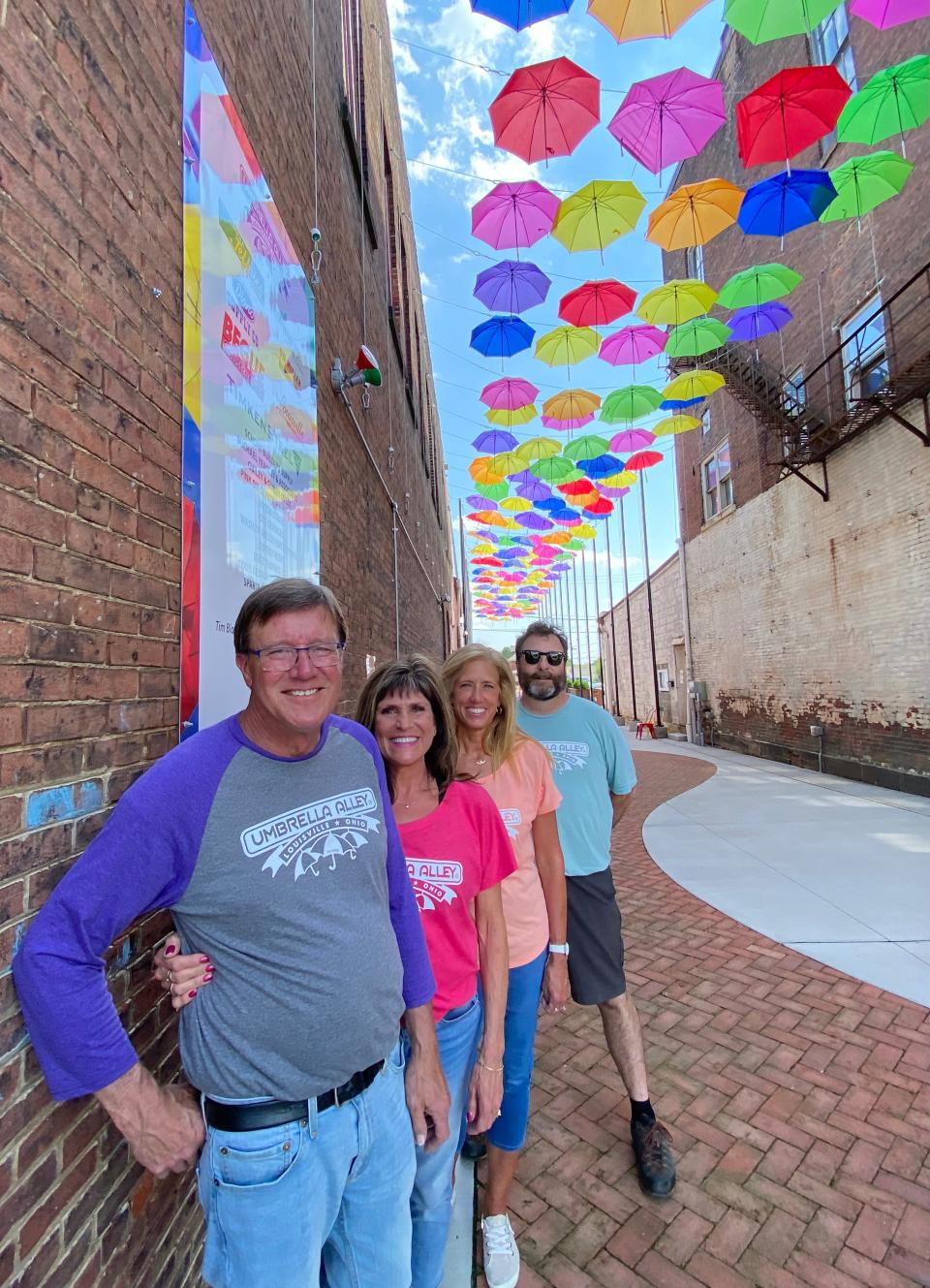 In this file photo from July 2021, Rick Guiley, Raeann Guiley, Tonda Mathie and David Yeagley pose for a photo in Umbrella Alley in downtown Louisville. They were in charge of programming at the time.