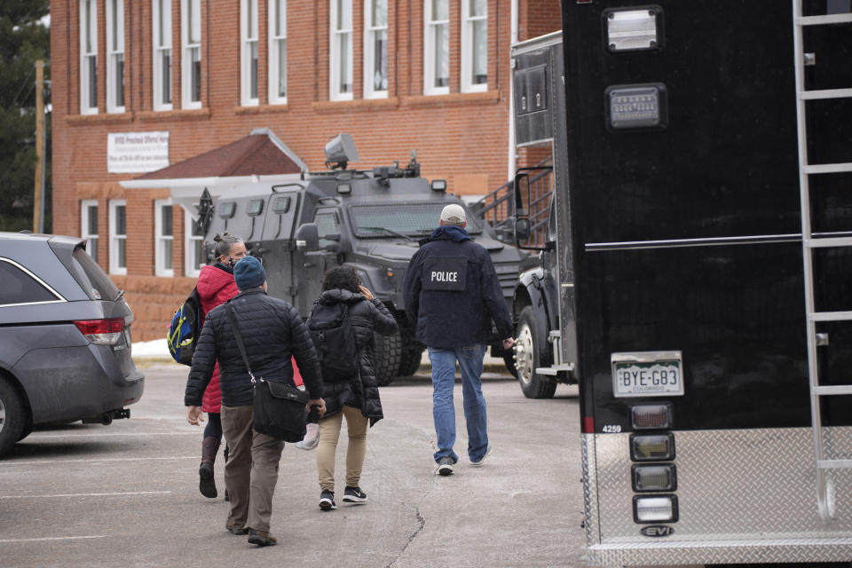 Police vehicles sit in front of University Hill Elementary School across from the campus of the University of Colorado after a man accused of making mass shooting threats against the college as well as the University of California, Los Angeles, was arrested Tuesday, Feb. 1, 2022, in Boulder, Colo. The police operation caused the evacuation of the elementary school and shelter-in-place orders for nearby residents on Boulder's University Hill. (AP Photo/David Zalubowski)