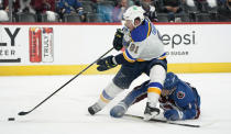 St. Louis Blues right wing Vladimir Tarasenko, front, drives to the net with the puck past Colorado Avalanche defenseman Devon Toews in the first period of Game 1 of an NHL hockey Stanley Cup first-round playoff series Monday, May 17, 2021, in Denver. (AP Photo/David Zalubowski)