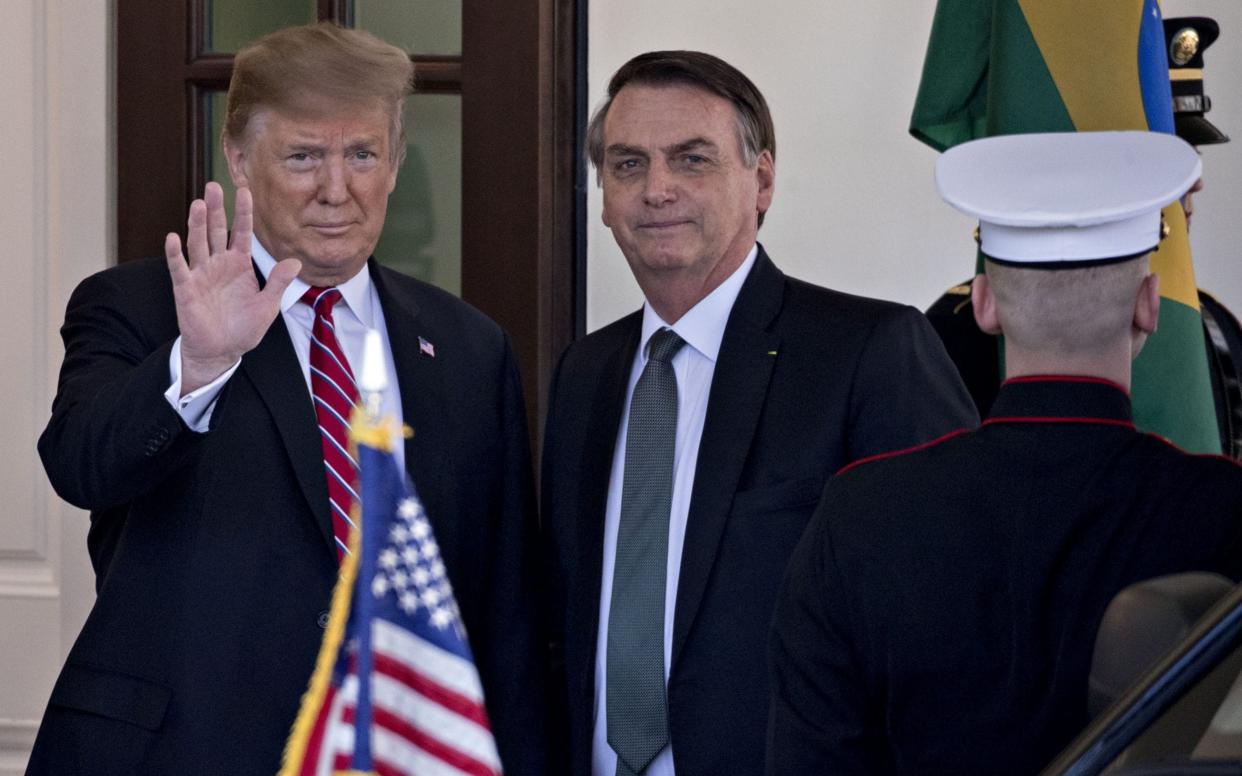 U.S. President Donald Trump, left, waves while standing with Jair Bolsonaro, Brazil's president, at the West Wing of the White House in Washington, D.C., U.S., on Tuesday, March 19, 2019. - Bloomberg