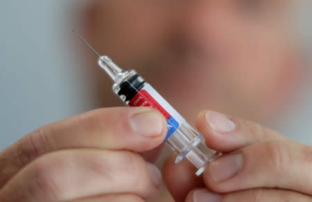 FILE PHOTO: A doctor hold a syringe as part of the start of the seasonal influenza vaccination campaign in Nice, France October 24, 2017.     REUTERS/Eric Gaillard/File Photo