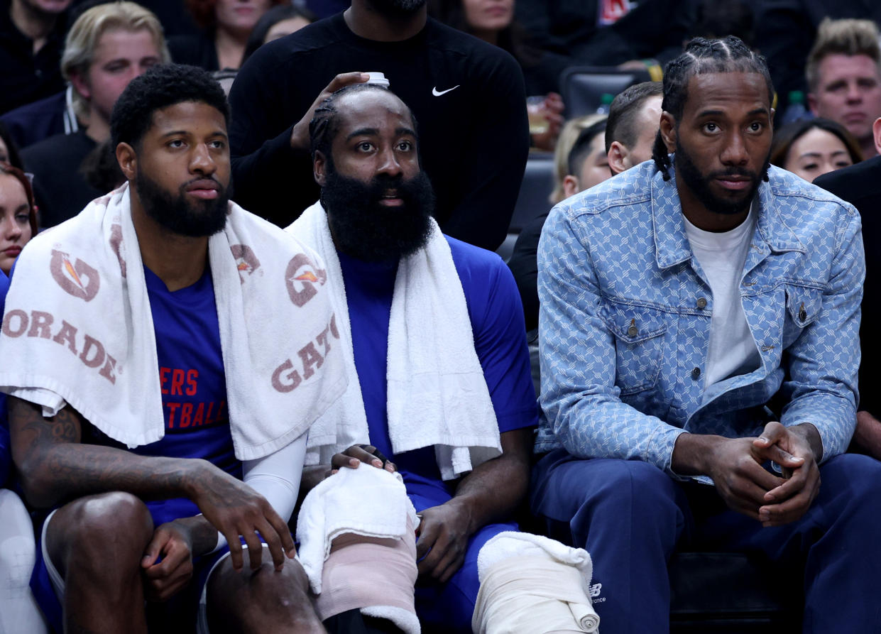 LOS ANGELES, CALIFORNIA - APRIL 12: (L-R) Paul George #13, James Harden #1 and Kawhi Leonard #2 of the LA Clippers watch play from the bench during a 110-109 loss to the Utah Jazz at Crypto.com Arena on April 12, 2024 in Los Angeles, California. User is consenting to the terms and conditions of the Getty Images License Agreement.  (Photo by Harry How/Getty Images)