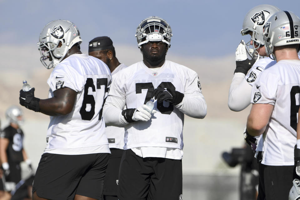 Las Vegas Raiders offensive tackle Alex Leatherwood (70) and teammates take a break during an NFL football practice Saturday, July 31, 2021, in Henderson, Nev. (AP Photo/David Becker)