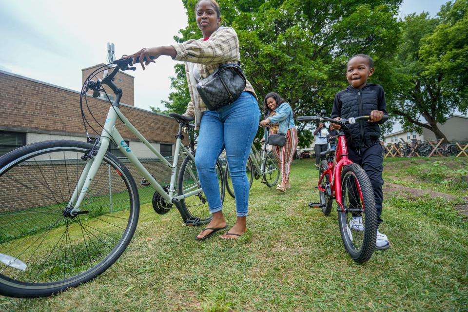 Alexis Cosey, from left, Sierra Randall and Chase, 7, who did not want to give his last name, smile as they get free bikes during Andre Lee Ellis' birthday party and bike giveaway on Saturday. "His little smile says it all," Cosey said. "This is a really nice event. Bikes are super expensive now with them being so popular in the pandemic and they are hard to find."