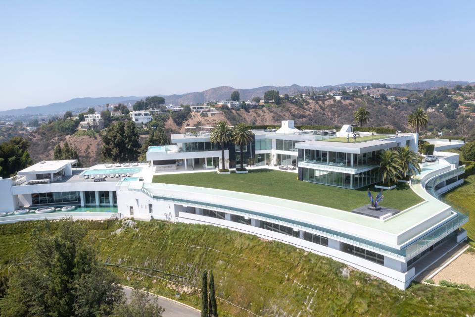 an aerial view of mansion The One Bel Air surrounded by hills and grass