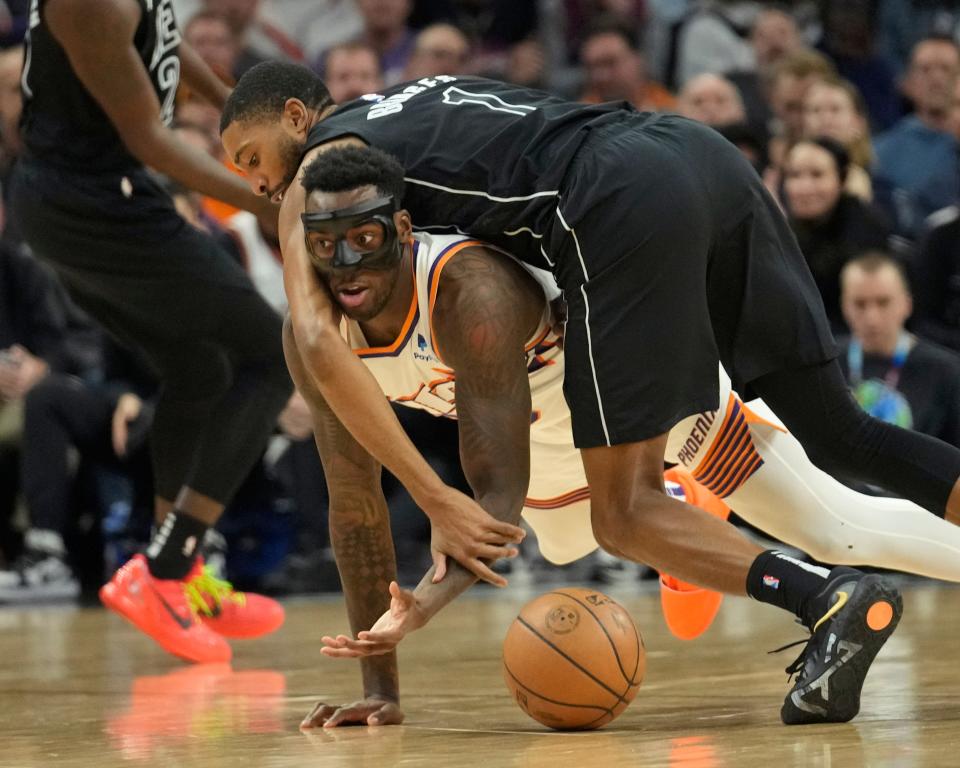 Phoenix Suns forward Nassir Little (25) is fouled by Brooklyn Nets forward Mikal Bridges (1) during the first quarter at Footprint Center in Phoenix on Dec. 13, 2023.