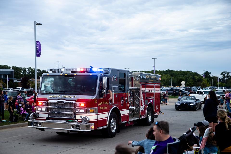 Members of the North Liberty Fire Department toss candy to community members during the Liberty High School homecoming parade Sept. 21.