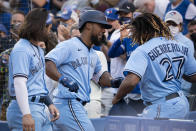 Toronto Blue Jays' Teoscar Hernandez, middle, celebrates with Vladimir Guerrero Jr. (27) after hitting a solo home run against the Kansas City Royals during the second inning of a baseball game Friday, July 30, 2021, in Toronto. The Blue Jays were playing in Toronto for the first time since the COVID-19 pandemic began.(Peter Power/The Canadian Press via AP)