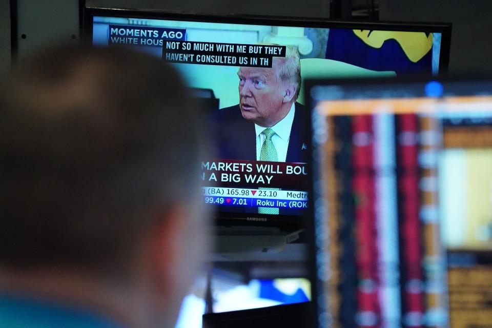 President Donald Trump speaks on television from the White House as traders work on the floor of the New York Stock Exchange on March 12, 2020 in New York. - Wall Street stocks were deep in the red early Thursday, resuming after a 15-minute suspension as the economic pain from the coronavirus deepens and widens. About 25 minutes into trading, the Dow Jones Industrial Average was at 21,505.07, down more than 2,000 points or 8.7 percent.The broad-based S&P 500 tumbled 8.1 percent to 2,519.43, while the tech-rich Nasdaq Composite Index shed 7.9 percent to 7,323.31. (Photo by Bryan R. Smith / AFP) (Photo by BRYAN R. SMITH/AFP via Getty Images)