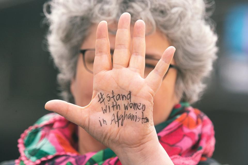 a woman with writing " stand with women in Afghanistan" on her palm is seen in front of Dom Cathedral in Cologne, Germany on May 30 during the protest against deportation of Asylum seekers from Afganhanistan in response the interior ministers conference in Würzburg