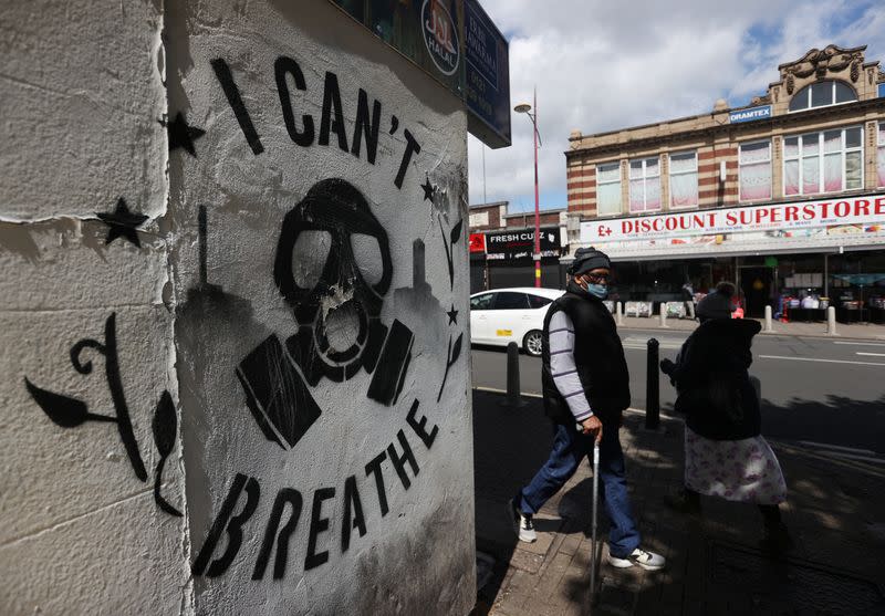 A man walks pat graffiti in Handsworth in relation to the death of George Floyd who died in police custody in Minneapolis