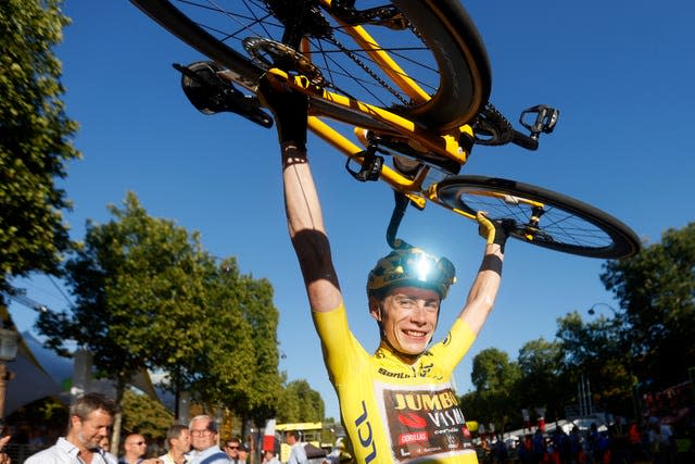 Tour de France winner Jonas Vingegaard lifts his bike above his head